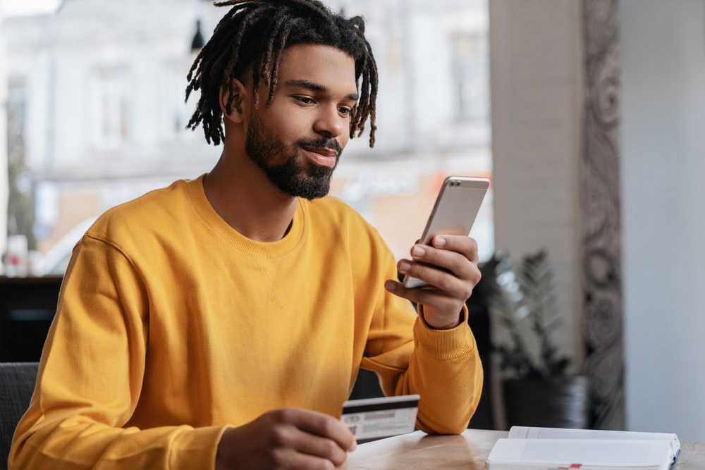 Black American reading about GSM and CDMA phone unlocking on a mobile device.