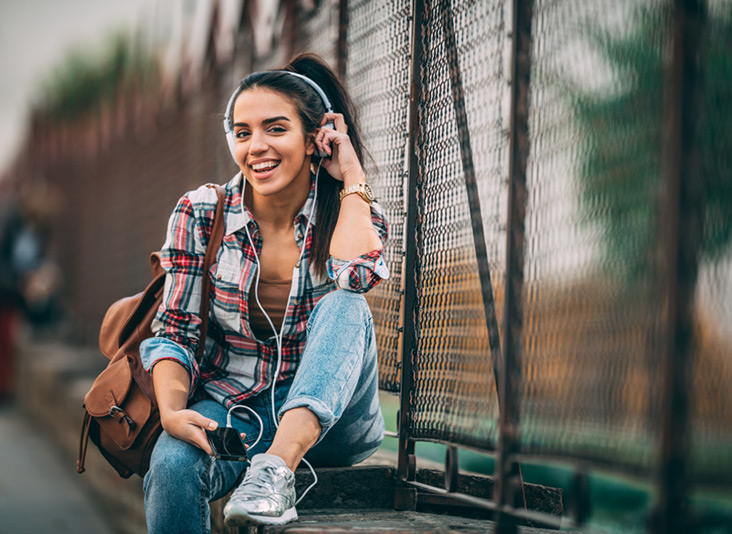 Sassy dark haired woman sat on a wall with her AT&T device unlock code.