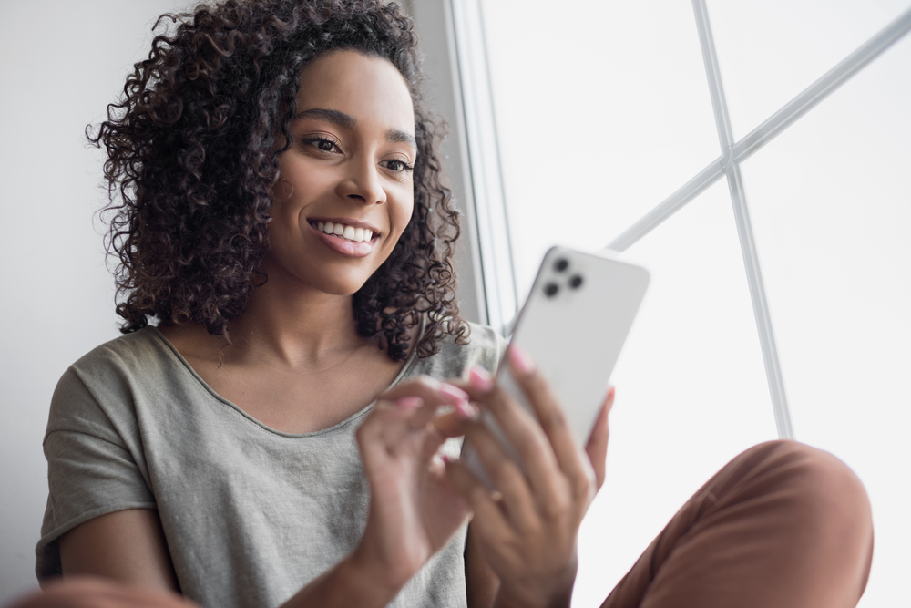 Atractiva mujer afroamericana que tiene un nuevo iPhone 14 Pro Max desbloqu