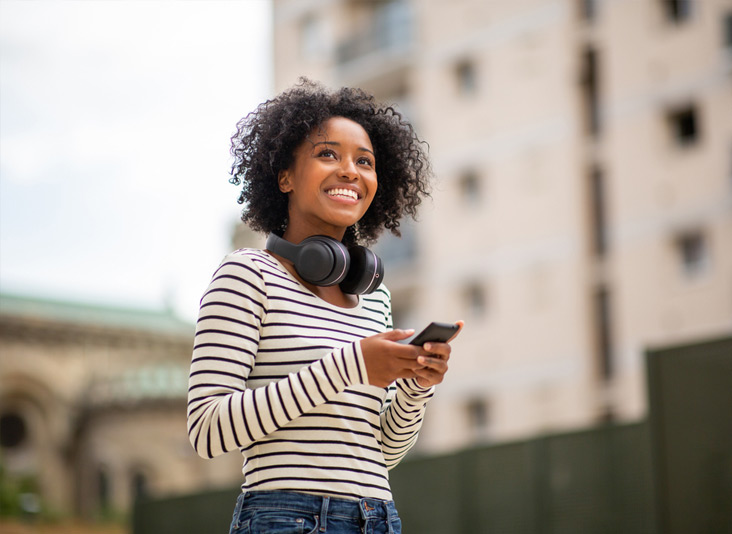 African Amercian woman smiling whilst holding her nTelos unlock handset.