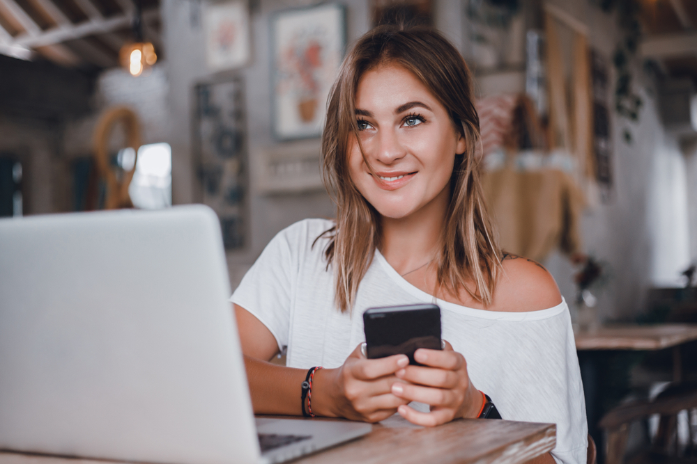 Attractive blond woman who appears to be happy since unlocking her EE phone.