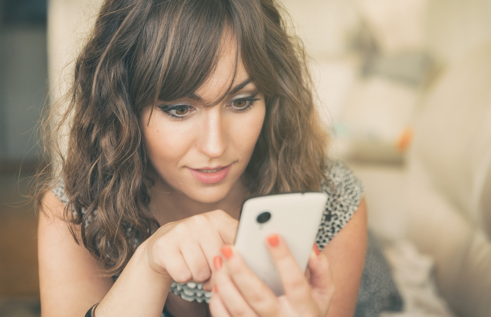 Beautiful woman curiously looking at an iPhone 8 unlock device screen.