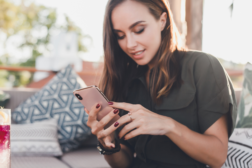 Beautiful woman in her twenties using her unlocked iPhone SE from Mobile Unlocked.