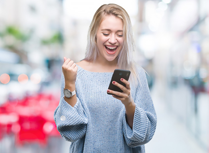 Blonde lady who is happy that she has a unlock Verizon Iphone code.